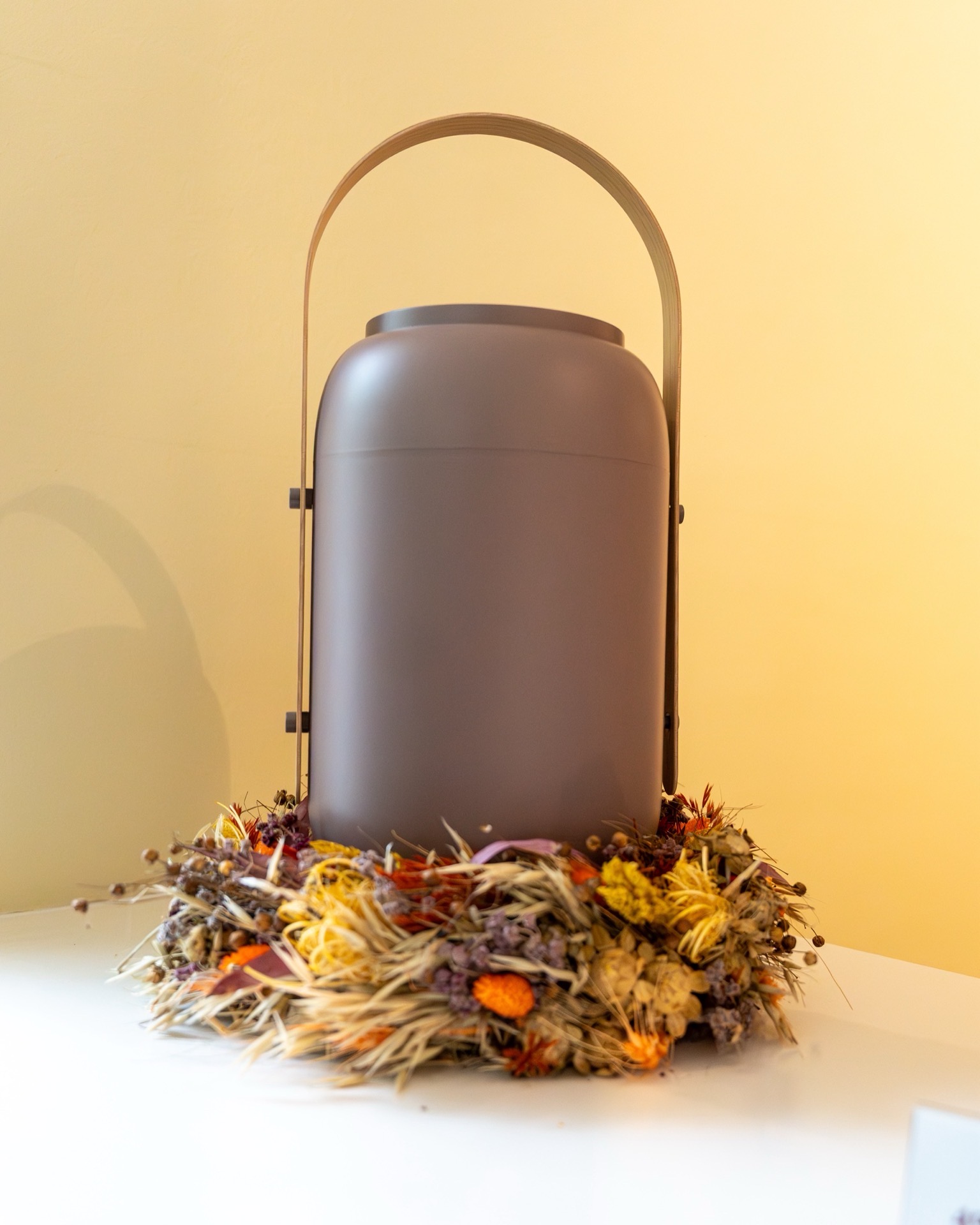 Urne mit Blumenkranz
