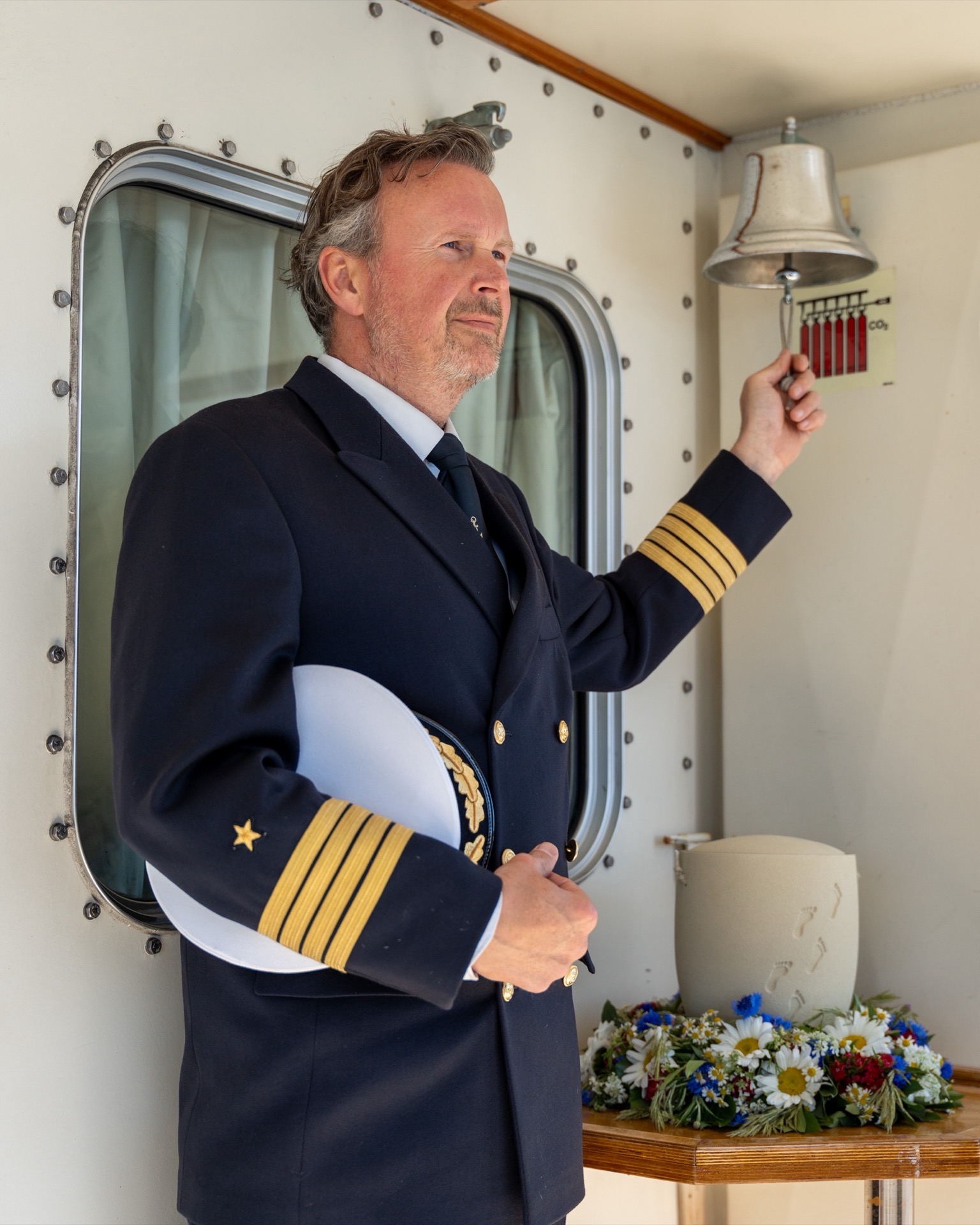 Kapitän bei einer Seebestattung auf der Elbe