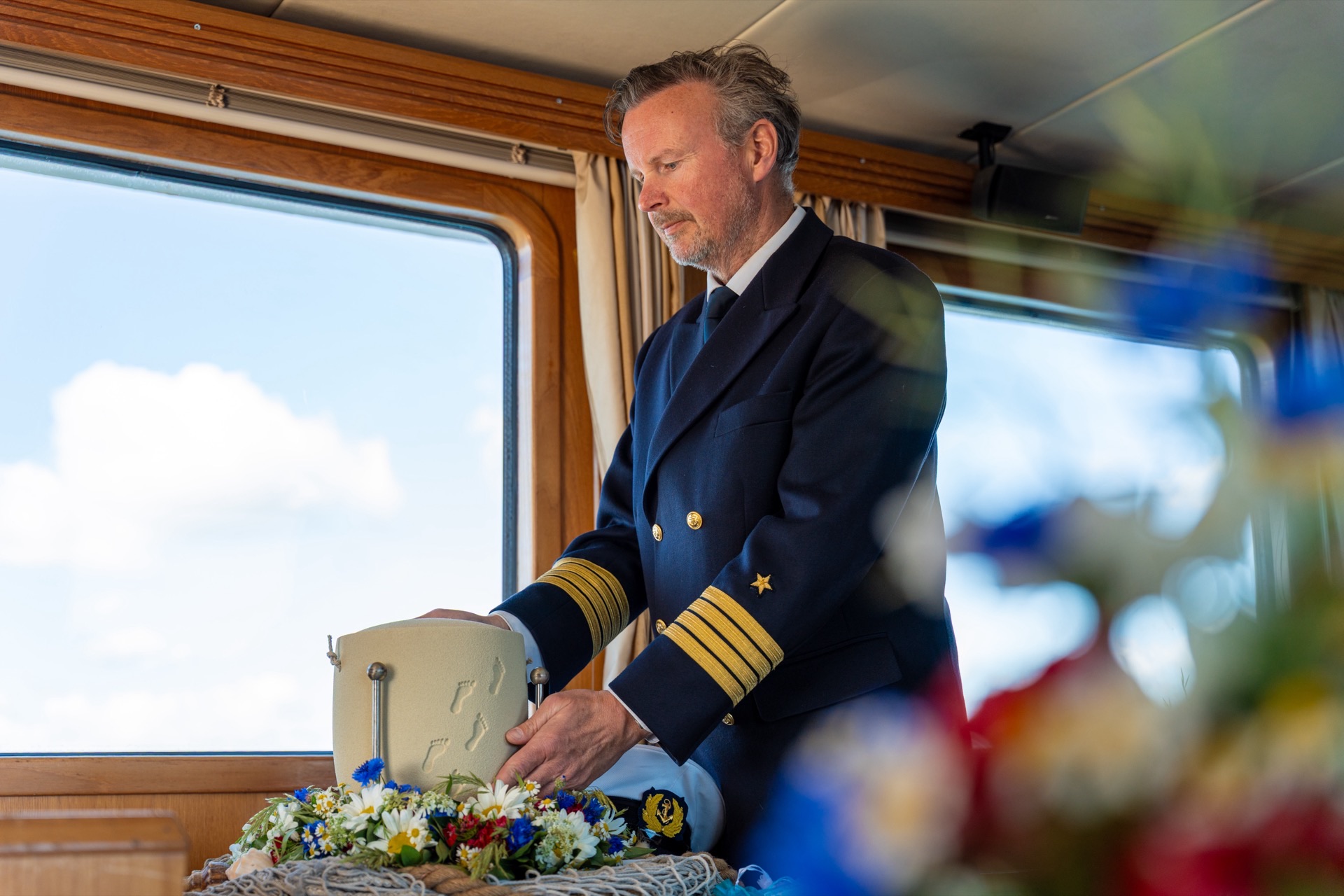 Kapitän mit Blumen an Bord