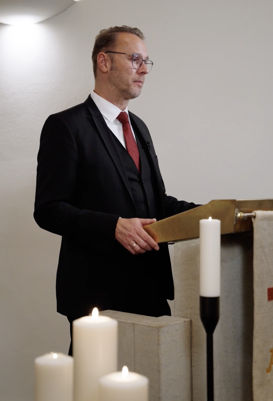 Björn Riggert hält eine Trauerrede am Pult